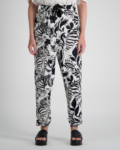 Roisin Adaptive Slouch Pants showcased in striking black and white botanical print on bamboo fabric, featuring tapered legs, drawstring waist, and relaxed fit. Styled with black platform sandals against light grey background.