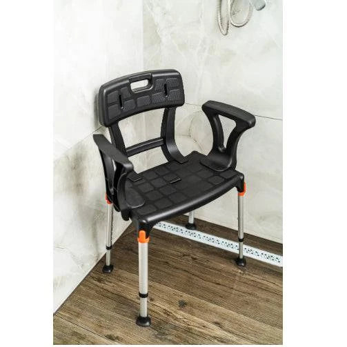 Black King Shower Seat with back and armrests positioned in a corner, designed for mobility support by Performance Health.
