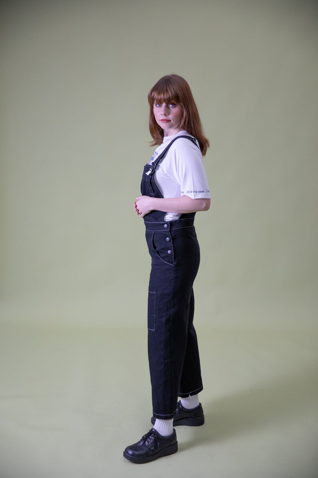 JAM the Label magnetic buckle overalls shown from the side, featuring adjustable straps and practical pockets in a casual clothing style.