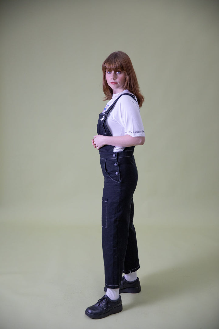 JAM the Label magnetic buckle overalls shown from the side, featuring adjustable straps and practical pockets in a casual clothing style.