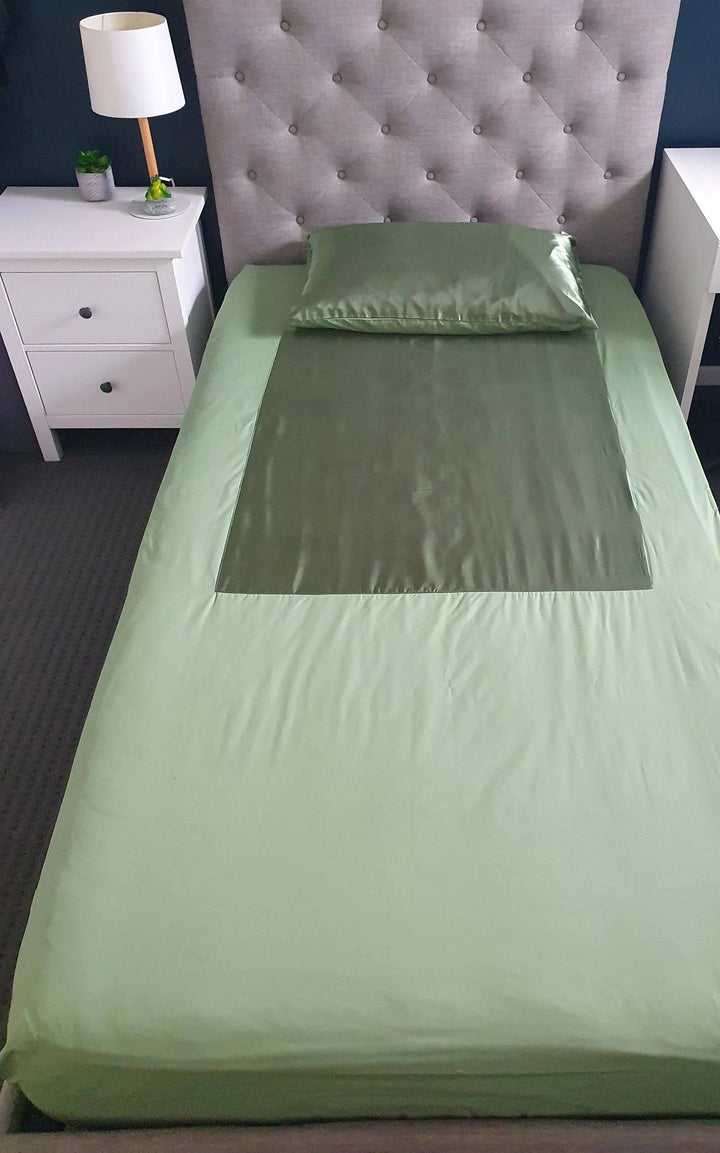 Neeki Designs Wonder PLUS Green Manchester pillow with vibrant green fabric and decorative stitching on soft textile.