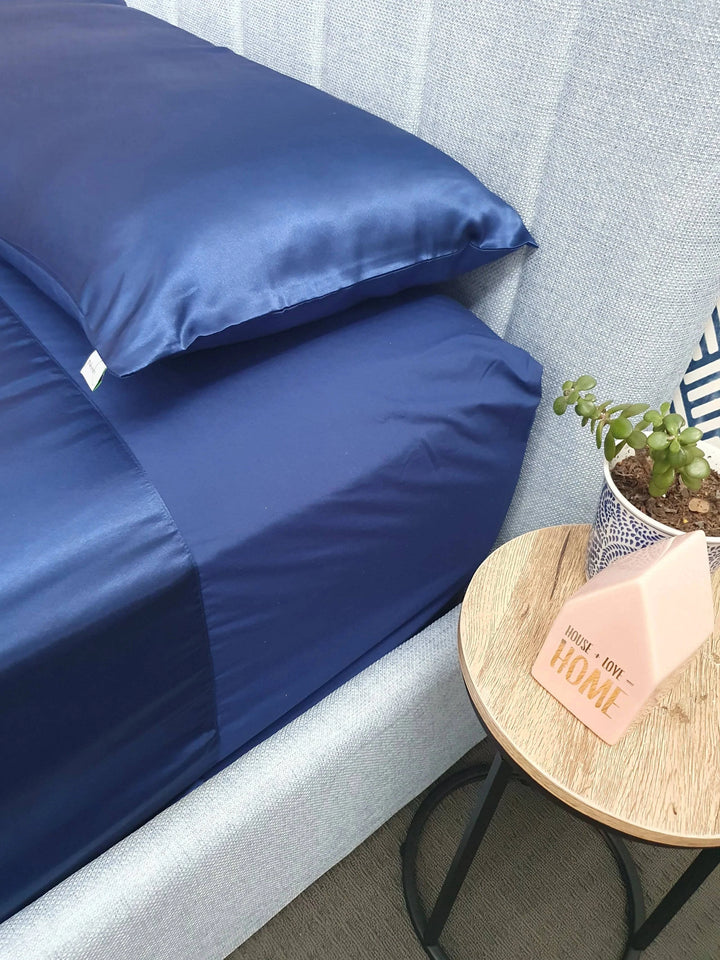 Blue Manchester Wonder Sheet by Neeki Designs, showing the soft, smooth fabric and neatly folded bedding on a bed.