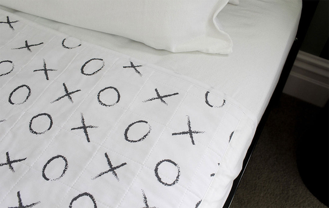 Brolly Sheets bed pad with wings in a hugs and kisses design, perfect for protecting bedding and ensuring comfort.