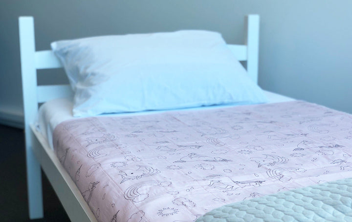 Dusty rose unicorn Brolly Sheets bed pad with wings, designed for added comfort and protection on mattresses.