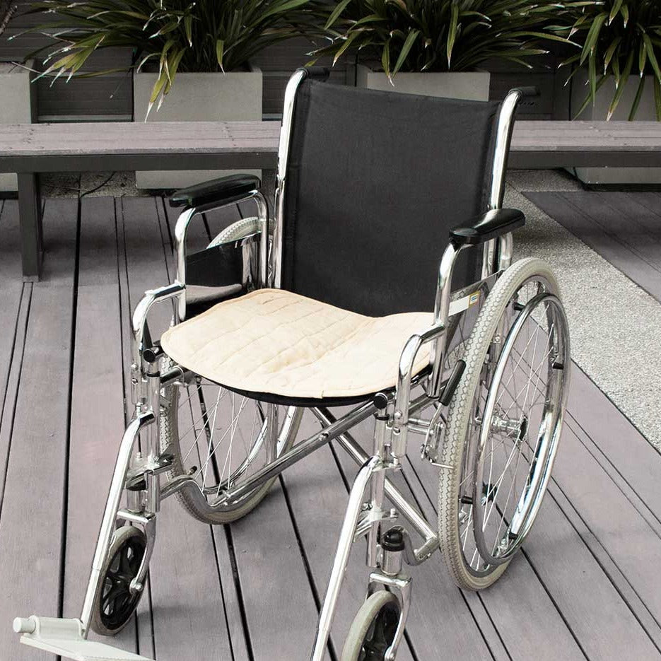 Double-sided waterproof Brolly Chair Pad in beige, designed for wheelchair comfort and protection.