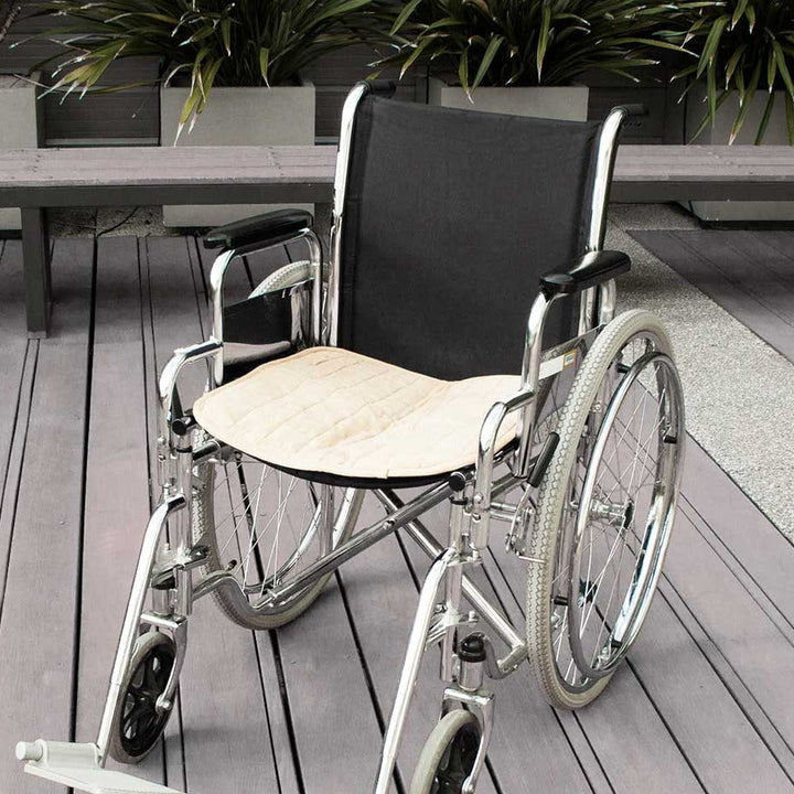 Double-sided waterproof Brolly Chair Pad in beige, designed for wheelchair comfort and protection.