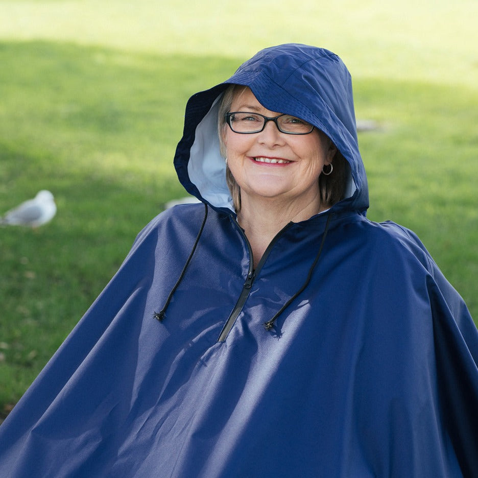 Diane wearing a Brolly Sheets Brolly Wheelchair Rain Coat for adaptive clothing, protecting against rain while seated in a wheelchair.