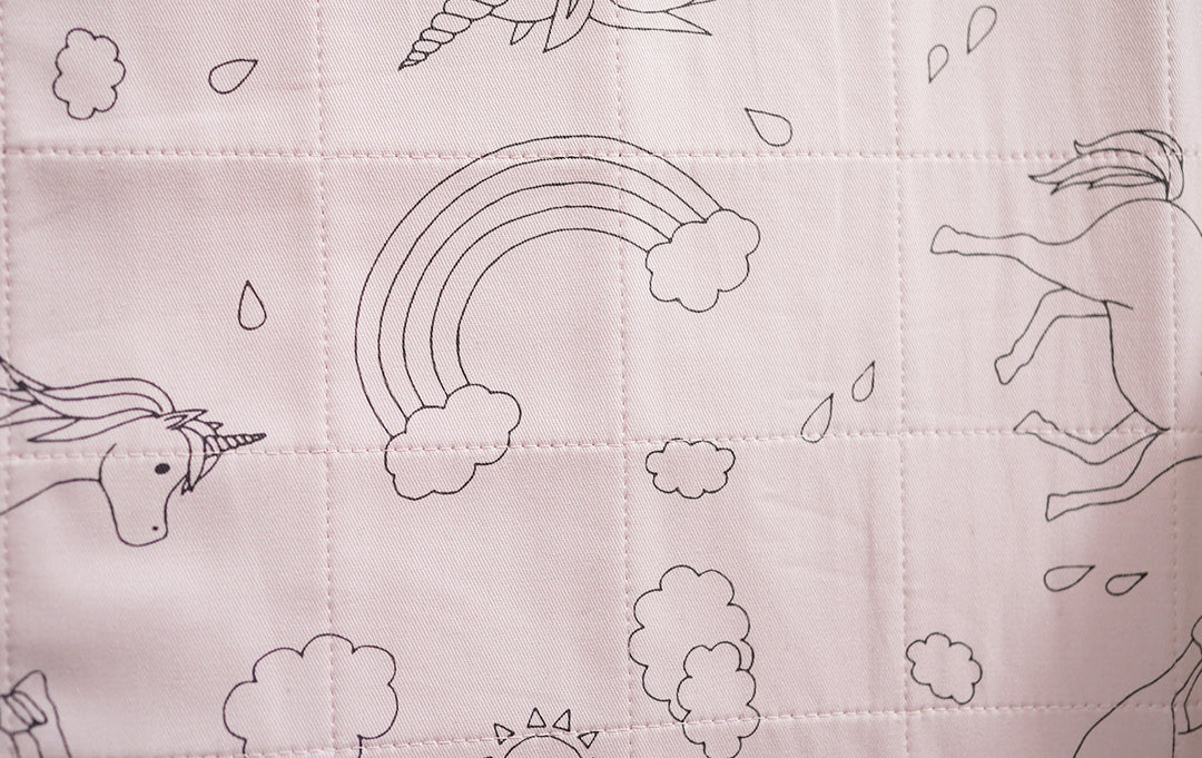 Dusty rose Brolly Sheets bed pad with wings featuring a unicorn design, soft fabric, and waterproof backing.