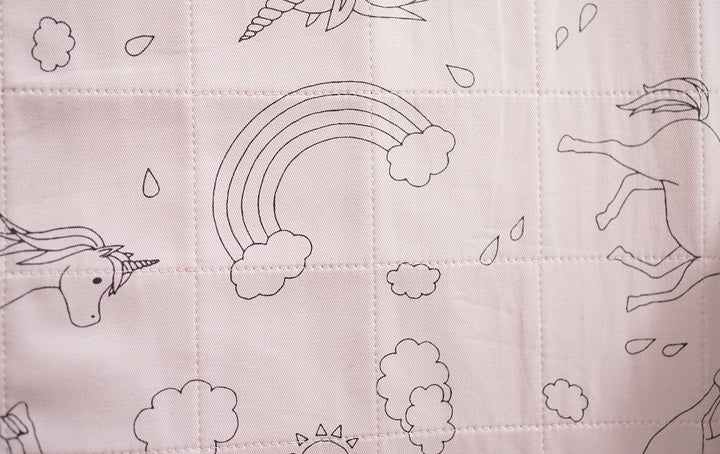 Dusty rose Brolly Sheets bed pad with wings featuring a unicorn design, soft fabric, and waterproof backing.