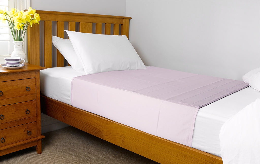 Pale pink Brolly Sheets bed pad with wings, designed for single and king single beds, showcasing soft fabric texture.