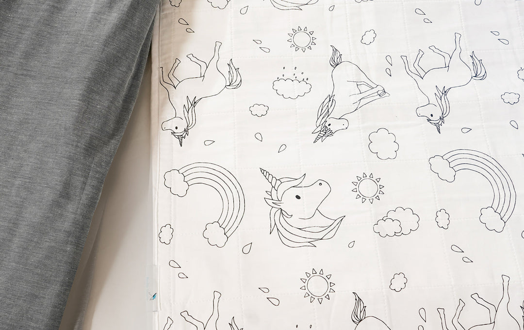 Brolly Sheets bed pad with wings, featuring a soft white fabric and cute unicorn design, ideal for bedwetting protection.